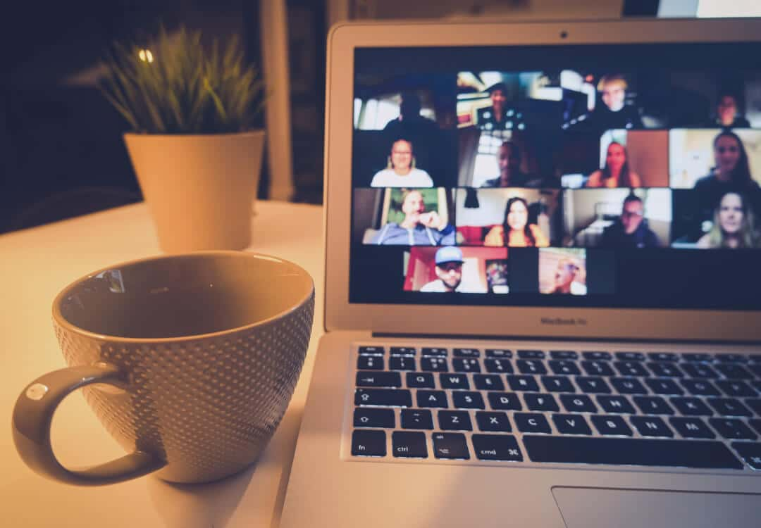 Laptop, auf dem ein Online Meeting im Video Call zu sehen ist